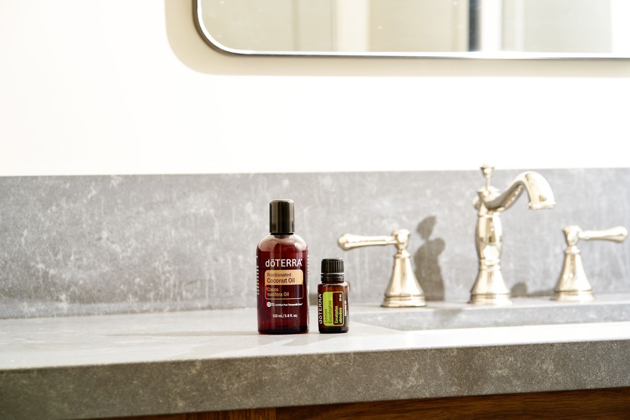 Beautiful display of essential oils on a modern bathroom countertop with a stylish faucet.