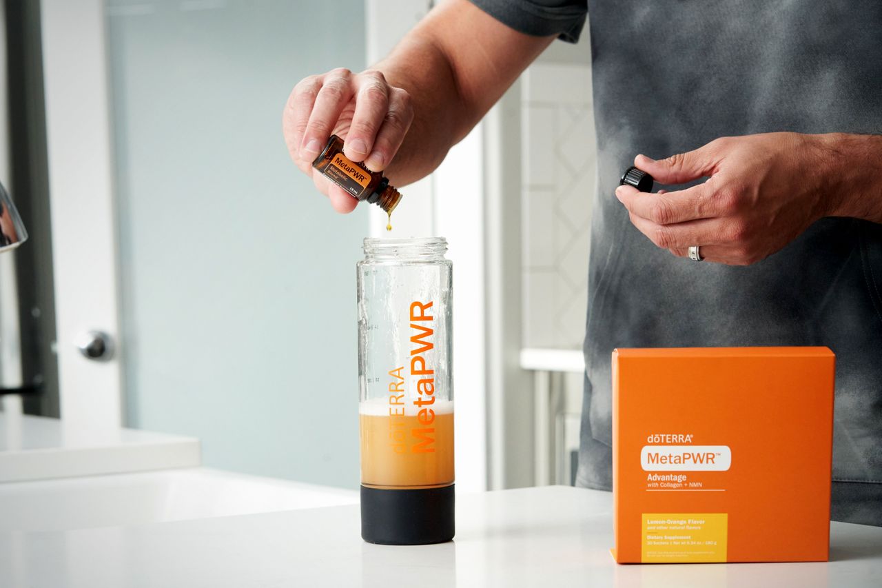 A person preparing a MetaPWR wellness drink, emphasizing health and vitality. Indoor scene.